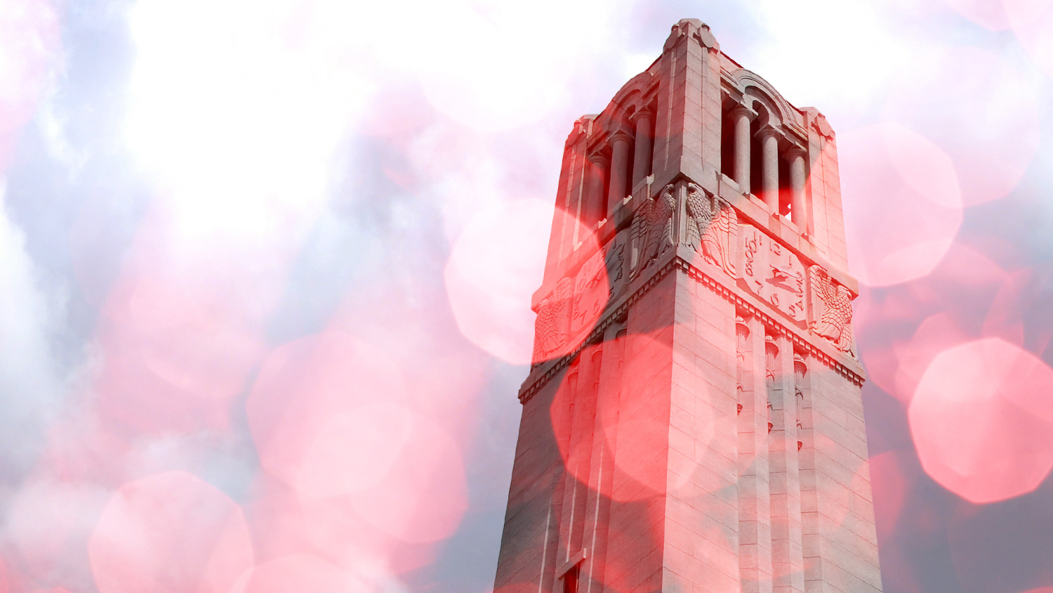 A stylized, rose-tinted shot of the NC State Memorial Bell Tower.