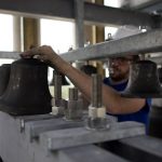 worker adjusting the position of a bell