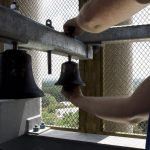 a worker installs a small bell