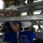 workers install bells in steel beams