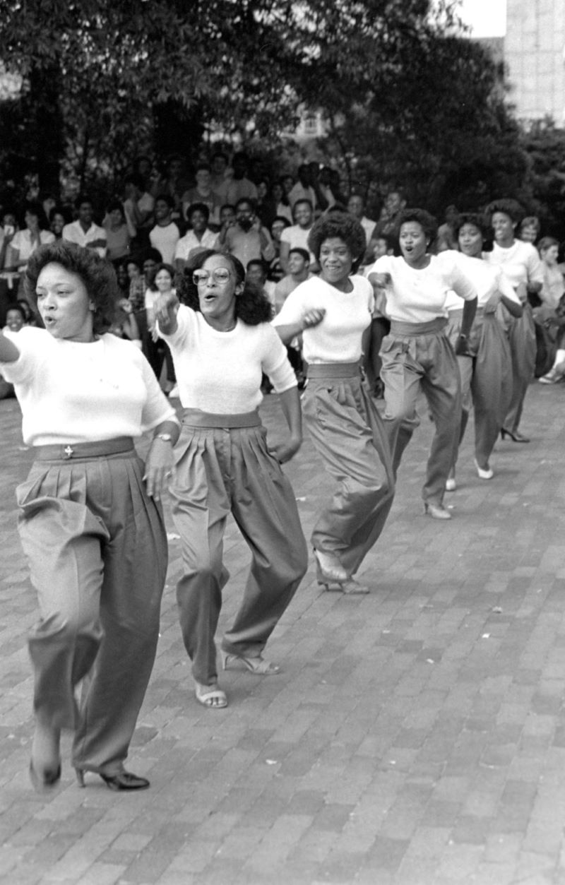 Black and white photo of sorority sisters performing a step show on the brickyard.