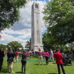 An audience gathers — in adherence to social-distancing guidelines — to witness the reopening of the Memorial Belltower and dedication of Henry Square.