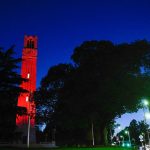 The Belltower lit red as seen from the traffic circle on Hillsborough Street