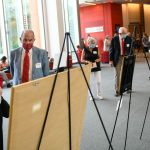 Attendees view a selection of Wolfpack art before the 2021 Pullen Society induction event